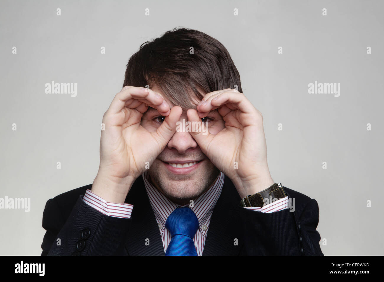 business-man-making-binocular-shape-hands-around-eyes-eyes-CERWKD.jpg