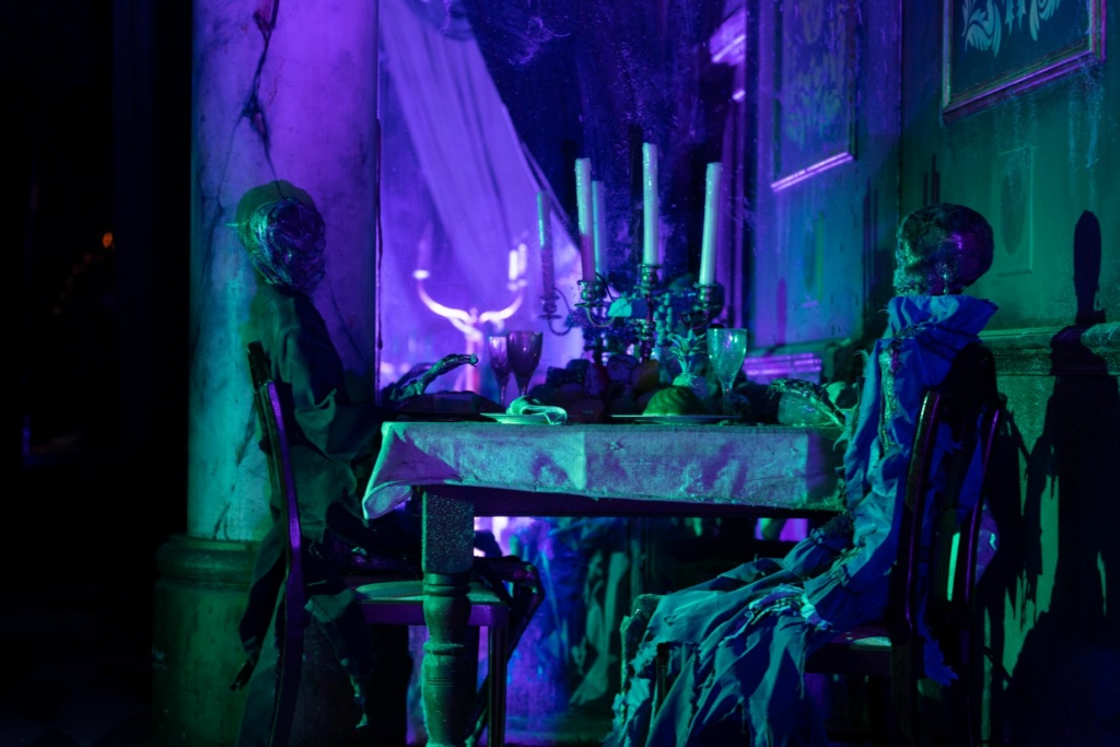 Two skeleton sit at a table in The Grand Hall